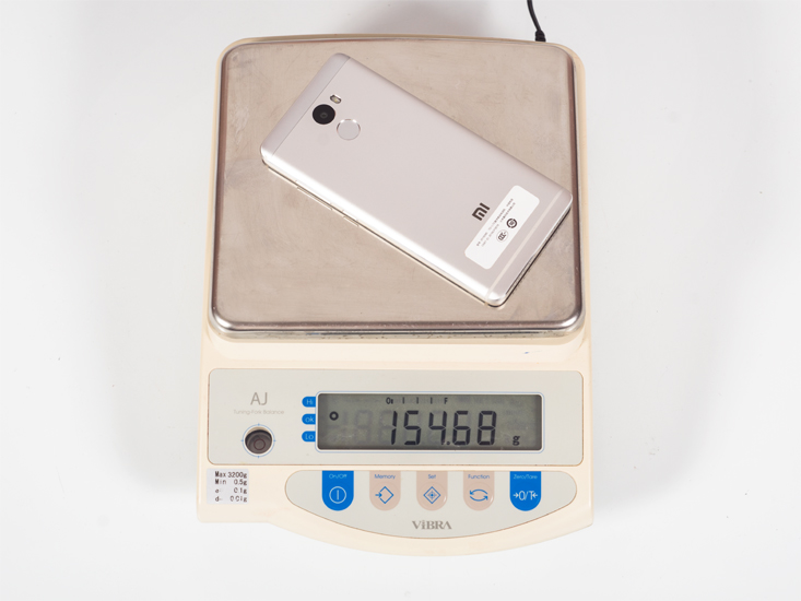 Смартфон Xiaomi Redmi 4 на весах.